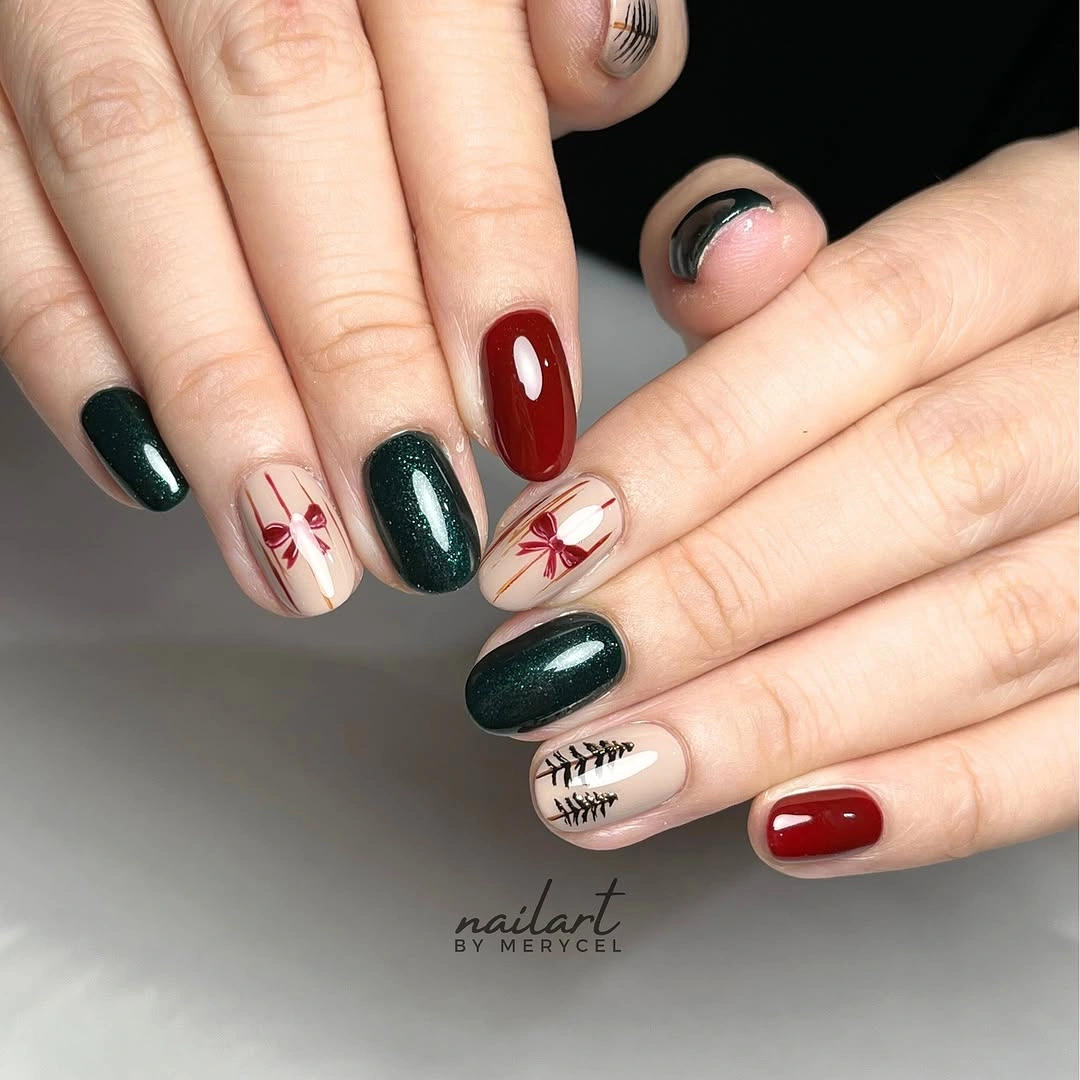 Rounded wine red and forest green nails with cream bows and branch accents