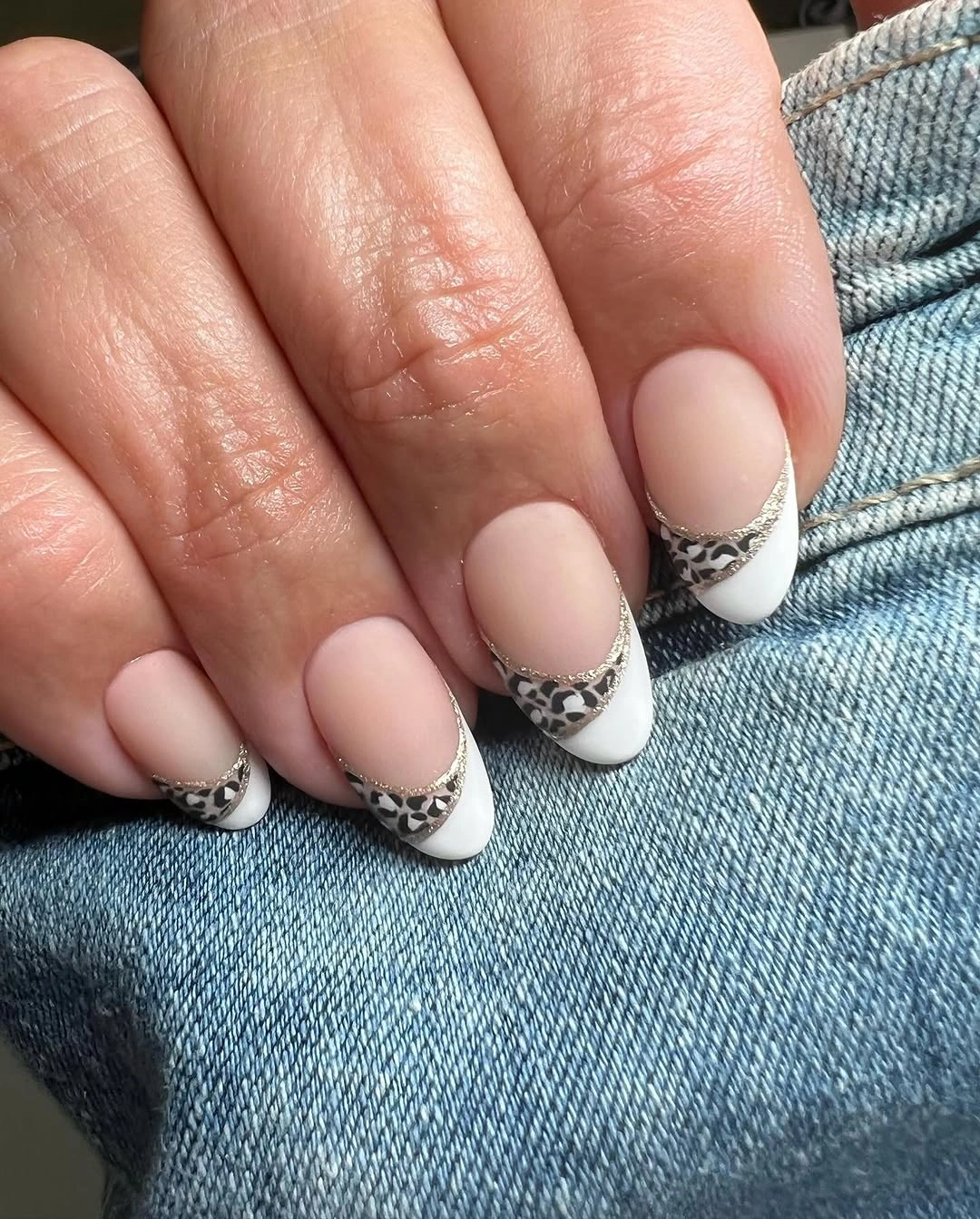 Nude almond nails with white French tips and gray-black animal-print inserts