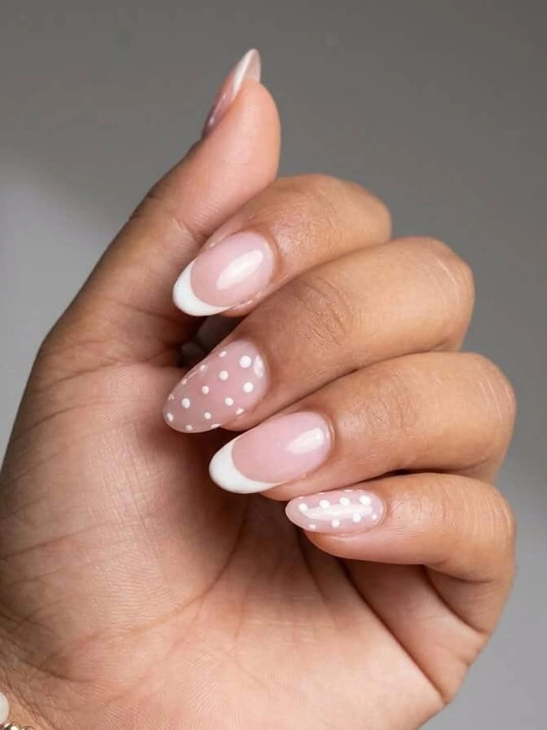 Pink almond nails alternating white French tips and small white polka dots